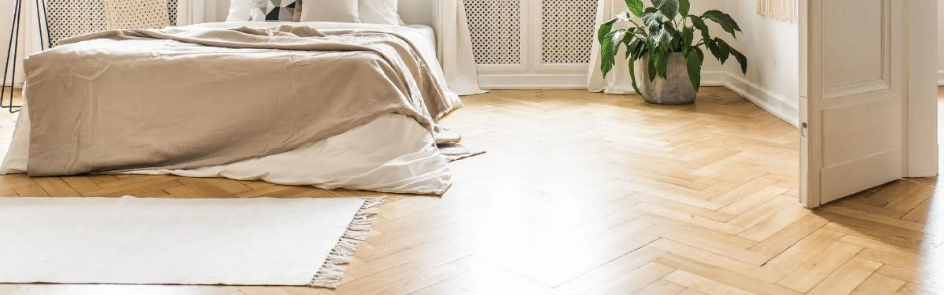 A bedroom that has a timber herringbone floor